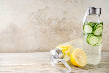 Organik yaz soğuk içecek, serinletici su, limon meyve ve salatalık sebze ile infüzyon detoks. Vegan yaşam, kilo kaybı ve fitness. Bir ışık ahşap arka plan üzerinde alanı Kopyala