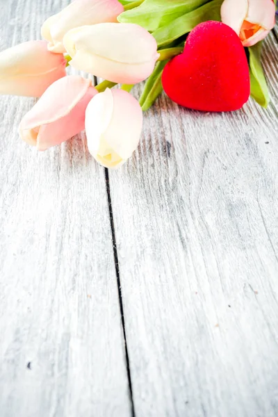 Valentine's day greetings postcard background, with tulips flowers and red heart, top view wooden background
