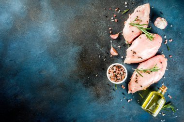 Ham taze tavuk göğsü fileto baharat ve biberiye koyu mavi beton zemin, metin kopyalama yeri olan üstten görünüm