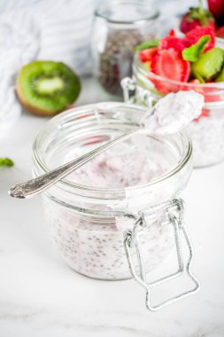 Sağlıklı diyet vejetaryen kahvaltı, chia tohum ve taze meyve, çilek, kivi ile yoğurt. Beyaz mermer zemin kopya alanı