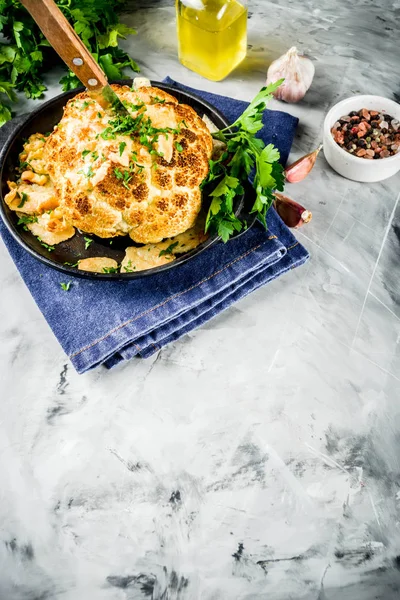 Ev yapımı tüm kavrulmuş karnabahar bir tavada zeytinyağı ve otlar ile. gri taş ya da mermer arka plan kopya alanı