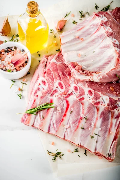 Çiğ et, domuz kaburga otlar ve baharatlar, beyaz mermer zemin ile alanı kopyalayın.