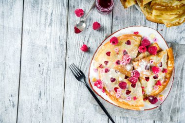 Sevgililer günü sürpriz hediye için fikir. Şirin krep krep berry ile sos ve kalp şekilli kesik. Romantik Sevgililer kahvaltı. Ahşap masa üzerinde taze ahududu ile. Kopya alanı