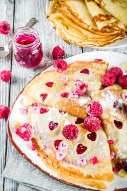 Sevgililer günü sürpriz hediye için fikir. Şirin krep krep berry ile sos ve kalp şekilli kesik. Romantik Sevgililer kahvaltı. Ahşap masa üzerinde taze ahududu ile. Kopya alanı