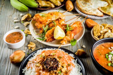 Batı Afrika gıda kavramı. Geleneksel gümüş Afrika yemekleri ürün çeşitliliği - fıstık çorba, jollof pilav, ızgara tavuk kanadı, Kuru kızarmış muz muz, Nijeryalı tavuk kebap, etli turtalar, üstten görünüm