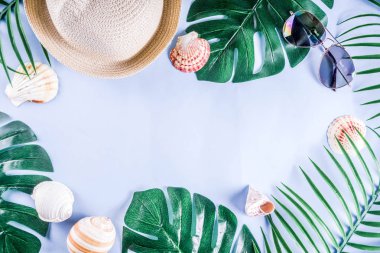 Renkli yaz tatili ve tatil düz-lay. Hasır şapka, güneş gözlüğü, palmiye ve monstera yaprakları parlak mavi sarı arka plan, üstten görünüm, kopya alanı