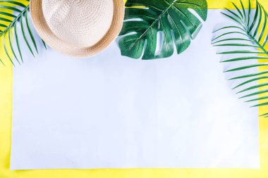 Renkli yaz tatili ve tatil düz-lay. Hasır şapka, güneş gözlüğü, palmiye ve monstera yaprakları parlak mavi sarı arka plan, üstten görünüm, kopya alanı