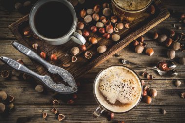 Ev yapımı fındık kahve latte veya kapuçino, rustik ahşap arka plan ile fındık, 3 kahve fincanı alanı kopyalama