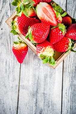 Küçük ahşap kutusunda, eski ahşap arka plan kopya alanı ham taze organik çilek 