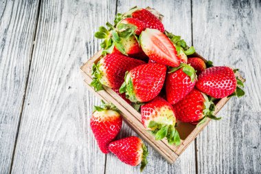 Küçük ahşap kutusunda, eski ahşap arka plan kopya alanı ham taze organik çilek 