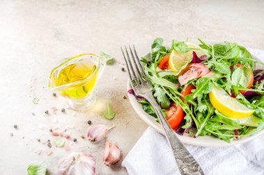 Taze bahar detoks karışımı salata sebze (salatalık, limon, domates, roka ve bebek ıspanak), ışık kayrak, taş veya beton arka plan ile. Üstten görünüm kopya alanı