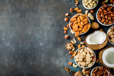 Fındık - ceviz, pecans, fıstık, fındık, Hindistan cevizi, badem, kaju fıstığı, çanaklar, koyu mavi beton masa üstü görünüm türleri