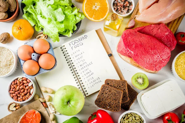 Sağlıklı bir diyet yemek. Çeşitli düşük fodmap malzemeler seçimi - et, sebze, berry, meyve, tahıl, Trendy sağlıklı yaşam konsepti. Beyaz mermer zemin kopya alanı üstten görünüm