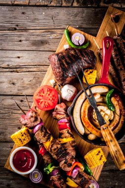 Çeşitler çeşitli barbekü yemek ızgara et, Barbekü partisi fest - şiş kebap, sosis, ızgara et fileto, taze sebze, soslar, baharatlar, kopya alanı yukarıda eski ahşap rustik masa üzerinde