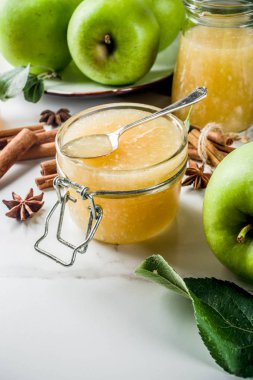 Ev yapımı elma reçel veya sosu, yeşil elma ve baharatlar, beyaz mermer zemin kopya alanı ile