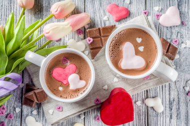 Sevgililer günü fikirleri tedavi eder, iki fincan sıcak çikolata ile marshmallow kalpleri ile kırmızı pembe beyaz çikolata parçacıkları, şeker parçacıkları, eski ahşap arka plan fotokopi alanı üst görünümü