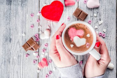 Kız sıcak çikolata hatmi kalpler, kırmızı pembe beyaz renk ile çikolata parçaları, şeker sprinkles, eski ile ahşap arka plan kopya alanı üstten görünüm, eller pictute flatlay eller