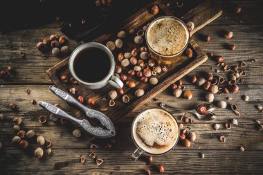 Ev yapımı fındık kahve latte veya kapuçino, rustik ahşap arka plan ile fındık, 3 kahve fincanı alanı kopyalama