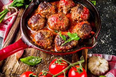 Karanlık paslı taş masada küçük tavada domates soslu ev yapımı Fırında köfte. Üstten görünüm kopya alanı