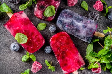 Basit ve sağlıklı yaz tatlı. Ev yapımı berry dondurma çubuklu dondurmayı nane ile. Mojito lolipopları çok, eti diyet su böğürtlen, yaban mersini ve ahududu ile aşılanmış. Karanlık beton arka plan kopya alanı üstten görünüm