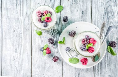 Yaz diyet kahvaltı, sağlıklı sabah tatlı yaz meyveleri - ahududu, yaban mersini, böğürtlen ile alakart kavanozlara Cheesecake tarifi fikirler. Ahşap arka plan kopya alanı üzerinde