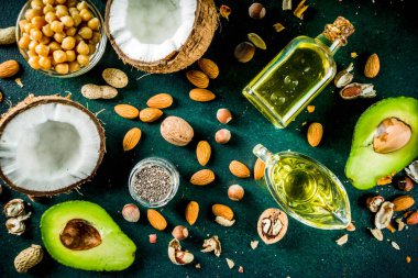 Sağlıklı vegan yağ gıda kaynakları, omega3, omega6 malzemeler - badem, ceviz, fındık, ceviz, zeytin yağı, chia tohumu, avokado, Hindistan cevizi, koyu yeşil arka plan kopya alanı