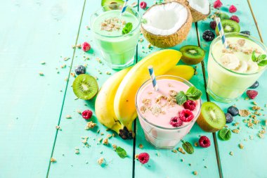 Yaz serinletici içecekler - protein shakes, milkshake veya smoothies, taze berry ve meyveler, mavi masa lambası ile alanı Kopyala