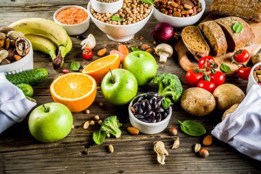 Healthy food. Selection of good carbohydrate sources, high fiber rich food. Low glycemic index diet. Fresh vegetables, fruits, cereals, legumes, nuts, greens. Wooden background copy space clipart