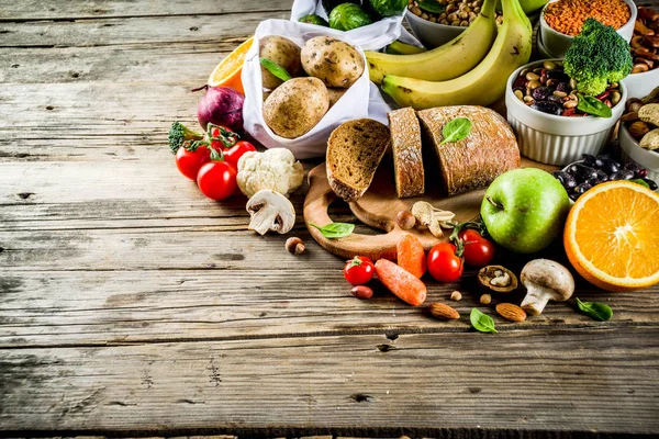 健康食品 良い炭水化物源 高繊維の豊富な食品の選択 低血糖インデックス ダイエット 新鮮な野菜 ナッツ 木製の背景コピー スペース — ストック写真