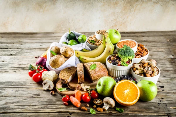 Healthy food. Selection of good carbohydrate sources, high fiber rich food. Low glycemic index diet. Fresh vegetables, fruits, cereals, legumes, nuts, greens. Wooden background copy space