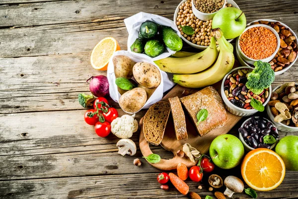 Healthy food. Selection of good carbohydrate sources, high fiber rich food. Low glycemic index diet. Fresh vegetables, fruits, cereals, legumes, nuts, greens. Wooden background copy space