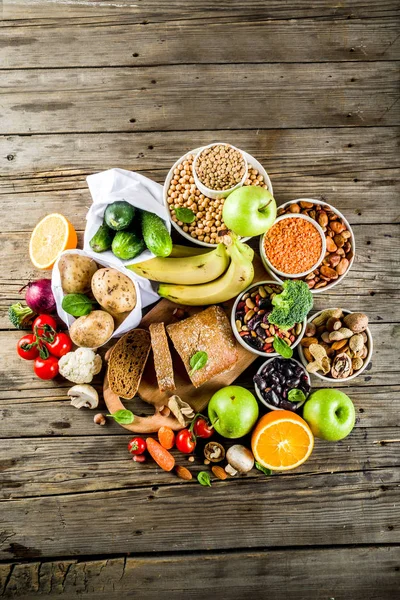 Healthy food. Selection of good carbohydrate sources, high fiber rich food. Low glycemic index diet. Fresh vegetables, fruits, cereals, legumes, nuts, greens. Wooden background copy space