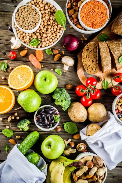 Healthy food. Selection of good carbohydrate sources, high fiber rich food. Low glycemic index diet. Fresh vegetables, fruits, cereals, legumes, nuts, greens. Wooden background copy space