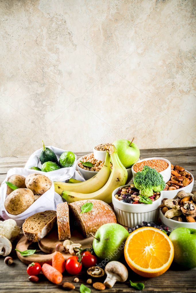 Healthy food. Selection of good carbohydrate sources, high fiber rich food. Low glycemic index diet. Fresh vegetables, fruits, cereals, legumes, nuts, greens. Wooden background copy space