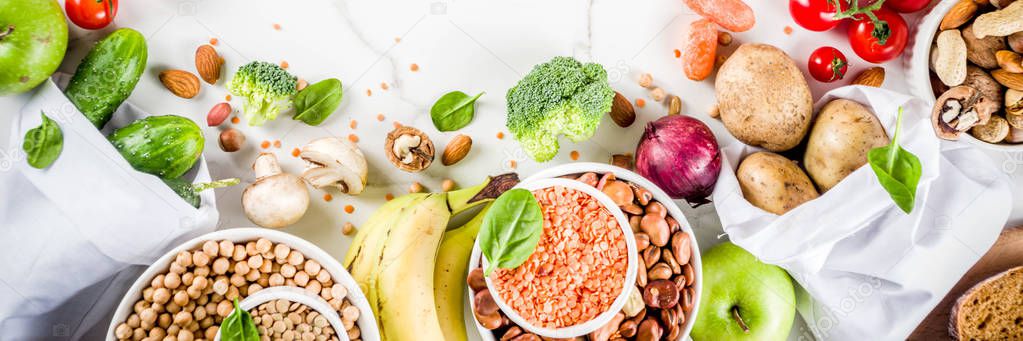 Healthy food. Selection of good carbohydrate sources, high fiber rich food. Low glycemic index diet. Fresh vegetables, fruits, cereals, legumes, nuts, greens. White marble background copy space banner