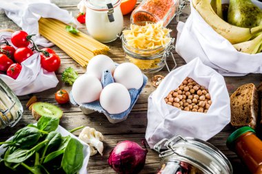 Atık alışveriş ve sustanable yaşam tarzı kavramı, çeşitli çiftlik organik sebzeler, tahıl, makarna, yumurta ve meyve yeniden kullanılabilir ambalaj süpermarket Çantalar sıfır. Kopyalama alanı üstten görünüm, ahşap arka plan