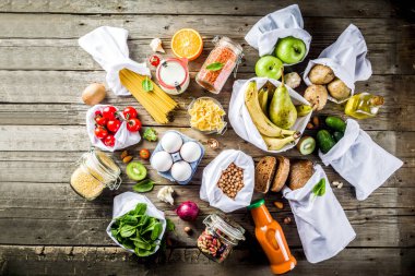 Atık alışveriş ve sustanable yaşam tarzı kavramı, çeşitli çiftlik organik sebzeler, tahıl, makarna, yumurta ve meyve yeniden kullanılabilir ambalaj süpermarket Çantalar sıfır. Kopyalama alanı üstten görünüm, ahşap arka plan