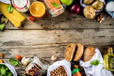 Atık alışveriş ve sustanable yaşam tarzı kavramı, çeşitli çiftlik organik sebzeler, tahıl, makarna, yumurta ve meyve yeniden kullanılabilir ambalaj süpermarket Çantalar sıfır. Kopyalama alanı üstten görünüm, ahşap arka plan