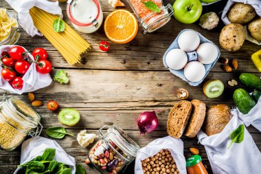 Atık alışveriş ve sustanable yaşam tarzı kavramı, çeşitli çiftlik organik sebzeler, tahıl, makarna, yumurta ve meyve yeniden kullanılabilir ambalaj süpermarket Çantalar sıfır. Kopyalama alanı üstten görünüm, ahşap arka plan