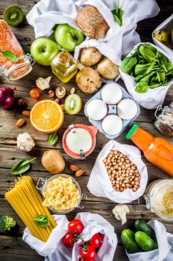 Atık alışveriş ve sustanable yaşam tarzı kavramı, çeşitli çiftlik organik sebzeler, tahıl, makarna, yumurta ve meyve yeniden kullanılabilir ambalaj süpermarket Çantalar sıfır. Kopyalama alanı üstten görünüm, ahşap arka plan