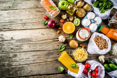 Atık alışveriş ve sustanable yaşam tarzı kavramı, çeşitli çiftlik organik sebzeler, tahıl, makarna, yumurta ve meyve yeniden kullanılabilir ambalaj süpermarket Çantalar sıfır. Kopyalama alanı üstten görünüm, ahşap arka plan