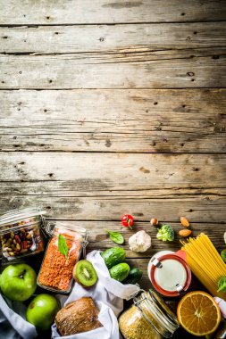 Atık alışveriş ve sustanable yaşam tarzı kavramı, çeşitli çiftlik organik sebzeler, tahıl, makarna, yumurta ve meyve yeniden kullanılabilir ambalaj süpermarket Çantalar sıfır. Kopyalama alanı üstten görünüm, ahşap arka plan