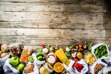 Atık alışveriş ve sustanable yaşam tarzı kavramı, çeşitli çiftlik organik sebzeler, tahıl, makarna, yumurta ve meyve yeniden kullanılabilir ambalaj süpermarket Çantalar sıfır. Kopyalama alanı üstten görünüm, ahşap arka plan