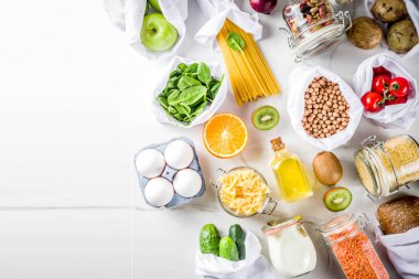 Atık alışveriş ve sustanable yaşam tarzı kavramı, çeşitli çiftlik organik sebzeler, tahıl, makarna, yumurta ve meyve yeniden kullanılabilir ambalaj süpermarket Çantalar sıfır. alanı yukarıdan, beyaz beton tablo kopyalama
