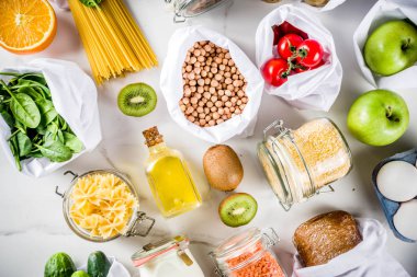 Atık alışveriş ve sustanable yaşam tarzı kavramı, çeşitli çiftlik organik sebzeler, tahıl, makarna, yumurta ve meyve yeniden kullanılabilir ambalaj süpermarket Çantalar sıfır. alanı yukarıdan, beyaz beton tablo kopyalama
