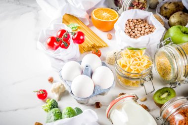 Atık alışveriş ve sustanable yaşam tarzı kavramı, çeşitli çiftlik organik sebzeler, tahıl, makarna, yumurta ve meyve yeniden kullanılabilir ambalaj süpermarket Çantalar sıfır. alanı yukarıdan, beyaz beton tablo kopyalama