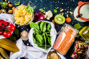 Atık alışveriş ve sustanable yaşam tarzı kavramı, çeşitli çiftlik organik sebzeler, tahıl, makarna, yumurta ve meyve yeniden kullanılabilir ambalaj süpermarket Çantalar sıfır. alanı yukarıdan, darb mavi tablo kopyalama