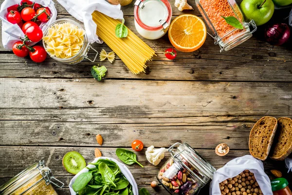 Atık alışveriş ve sustanable yaşam tarzı kavramı, çeşitli çiftlik organik sebzeler, tahıl, makarna, yumurta ve meyve yeniden kullanılabilir ambalaj süpermarket Çantalar sıfır. Kopyalama alanı üstten görünüm, ahşap arka plan