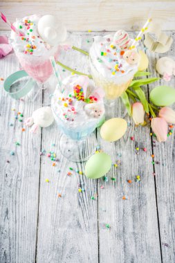 Komik Paskalya gıda, çocuklar parti, renkli mavi sarı pembe milkshakes şeker ile sprinkles, Paskalya yumurtası ve bunny tavşan dekorasyon, ahşap arka plan Paskalya için fikirler yemek tarifleri alanı Kopyala