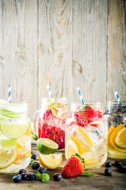 Çeşitli meyve ve meyve limonata içecekler, ferahlık infüzyon seçimi, su taze çilek, limon, limon, portakal, yaban mersini, mason kavanoz ahşap arka plan kopya alanı